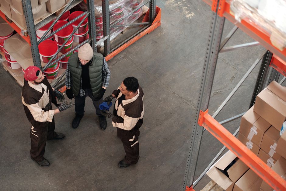 warehouse labor management workers reviewing performance data in distribution center